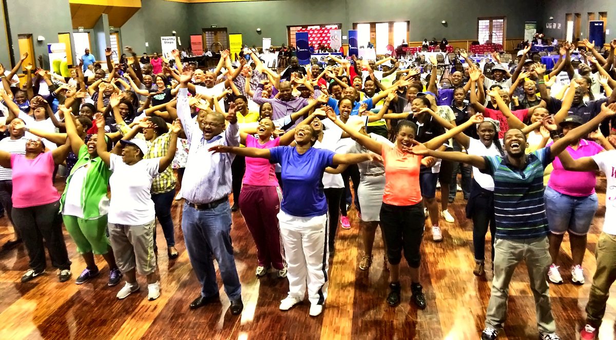 Five hundred people with arms raised at an Eskom session